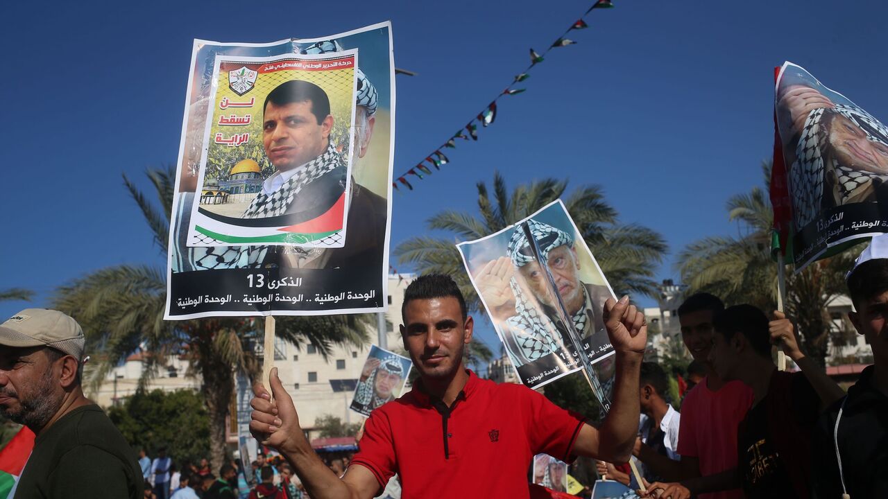 872051268 Palestinians hold pictures of late leader Yasser Arafat in Gaza City on November 9, 2017, during a festival to commemorate the 13th anniversary of his death.
According to organisers, the event was called by exiled Palestinian politician Mohammed Dahlan (portrait), partly to celebrate a recently agreed reconciliation agreement between the major Palestinian factions Hamas and Fatah. Dahlan has been in exile in the UAE since falling out with Palestinian president Mahmud Abbas and expelled from his Fatah movem