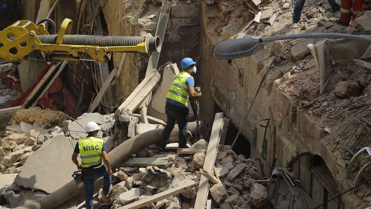 Rescue workers prepare to use a tube to vacuum debris from a badly damaged building in Lebanon's capital Beirut, in search of possible survivors from a mega-blast at the adjacent port one month ago, after scanners detected a pulse, on September 4, 2020. - Lebanese rescuers scoured rubble for a possible survivor in Beirut after the detection of a pulse drew crowds hopeful of a miracle one month on from a devastating explosion. (Photo by JOSEPH EID / AFP) (Photo by JOSEPH EID/AFP via Getty Images)