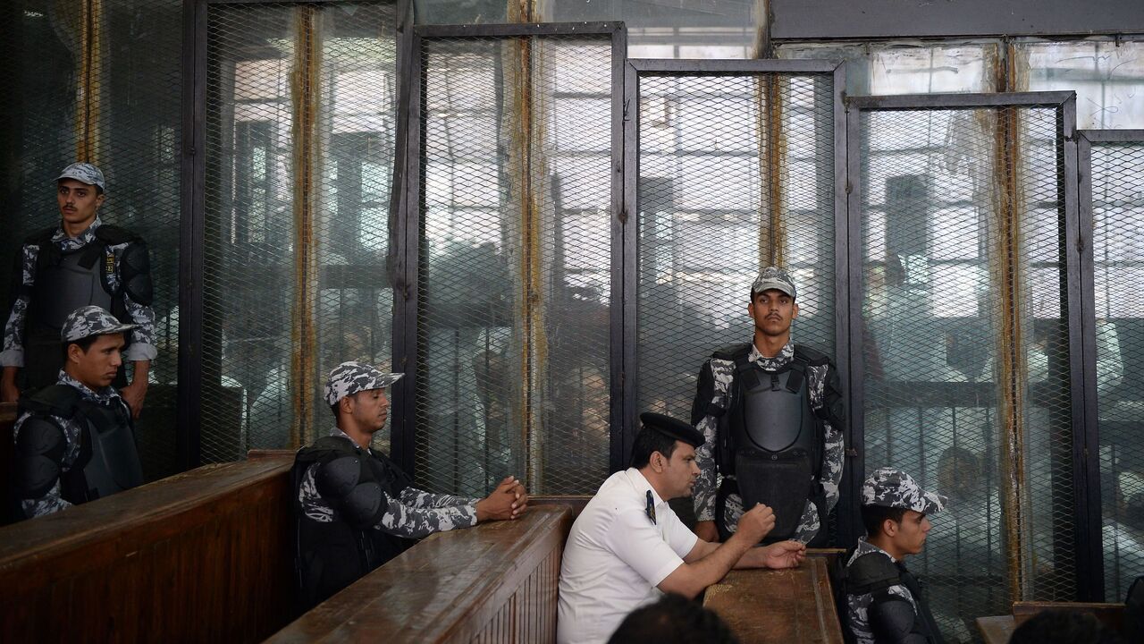 1029046930 TOPSHOT - This picture shows the courtroom and soundproof glass dock (bottom) during the trial of 700 defendants including Egyptian photojournalist Mahmoud Abu Zeid, widely known as Shawkan, in the capital Cairo, on September 8, 2018. - Shawkan, who earlier this year received UNESCO's World Freedom Prize, was on September 8 handed a five-year jail sentence in a trial including over 700 other defendants over charges of killing police and vandalising property during the clashes, some of which were also handed