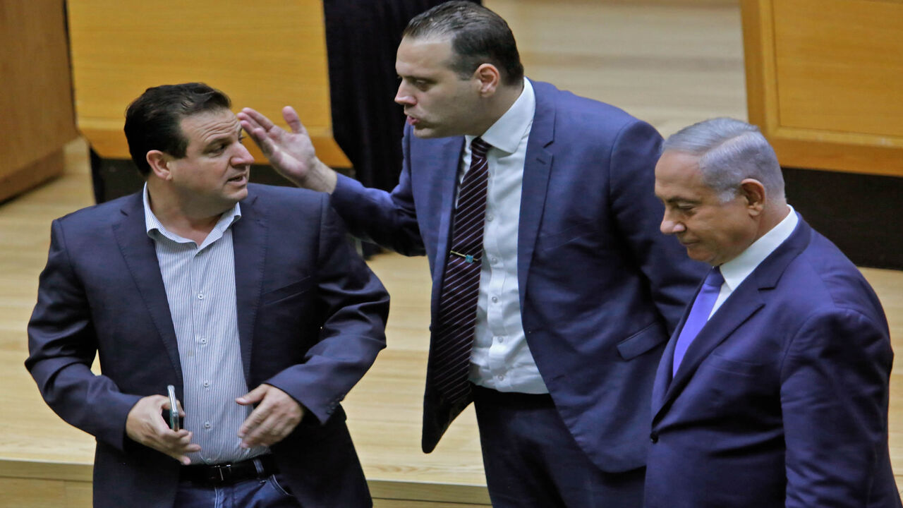 1167369470 Israeli Knesset member (MK) Miki Zohar (C) intervenes between Israeli-Arab MK Ayman Odeh (L) and Prime Minister Benjamin Netanyahu (R) following an argument in the main Knesset chamber in Jerusalem on September 11, 2019. - A rare clash erupted between Netanyahu and Joint List Chairman Odeh on September 11 at the Knesset during a discussion ahead of a vote on a controversial, Likud party-sponspored bill to allow cameras in polling booths. (Photo by Gil COHEN-MAGEN / AFP) (Photo credit should read GIL
