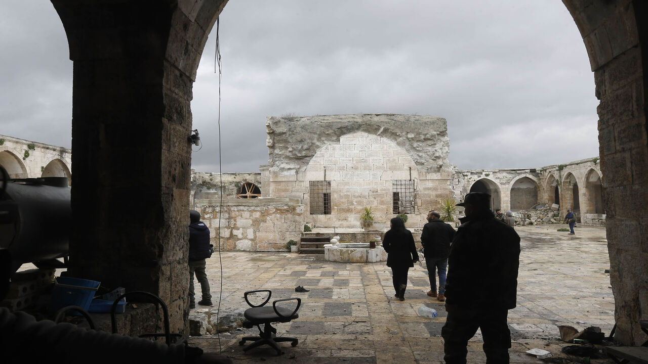1197679002 Syrian pro-regime fighters and journalists enter the courtyard of the museum of Maaret al-Numan in Syria's northwestern Idlib province on January 30, 2020. - Maaret al-Numan is nestled in a UNESCO-listed region of ancient villages and its mosaics museum had achieved international renown.
The museum, housed in an Ottoman-era caravanserai, was seriously damaged in a government barrel bomb attack in 2015. (Photo by LOUAI BESHARA / AFP) (Photo by LOUAI BESHARA/AFP via Getty Images)