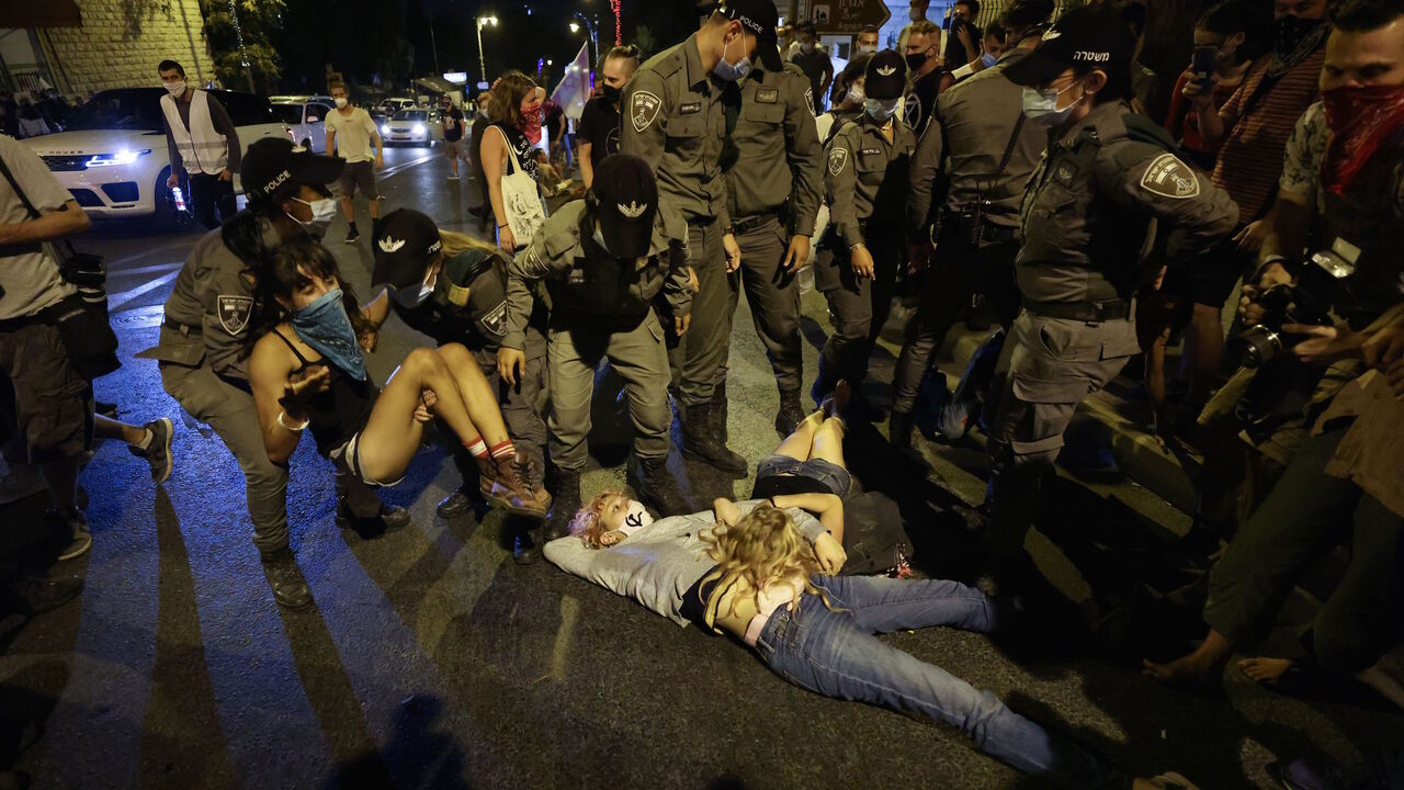 1228261992 Police carry away a protester during an anti-government demonstration in front of the Prime Minister's residence in Jerusalem on August 29, 2020. - Protests demanding that Israeli Prime Minister Benjamin Netanyahu resign over several corruption indictments and his handling of the coronavirus crisis have been mounting in recent weeks, and the premier has been scathing in his counter-attack. (Photo by Emmanuel DUNAND / AFP) (Photo by EMMANUEL DUNAND/AFP via Getty Images)