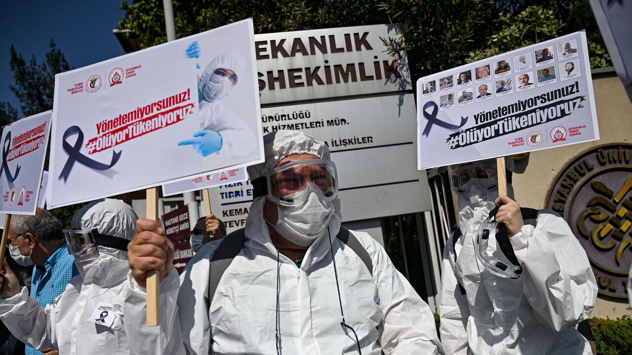 1228523336 Health workers and doctors wearing personal protective equipment (PPE) hold placards reading "You cannot manage, we are dying - We are running out" during a demostration against goverments health policy on September 15, 2020 in front of Istanbul University medical faculty. (Photo by Ozan KOSE / AFP) (Photo by OZAN KOSE/AFP via Getty Images)