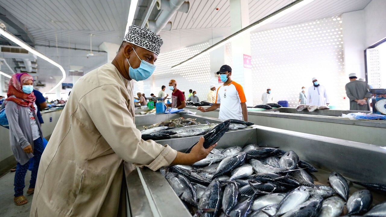 1228571645 A vendor wearing a face mask against the coronavirus sells fresh fish at the Mutrah Souq (Mutrah market) in the Omani capital Muscat on September 18, 2020. (Photo by Haitham AL-SHUKAIRI / AFP) (Photo by HAITHAM AL-SHUKAIRI/AFP via Getty Images)