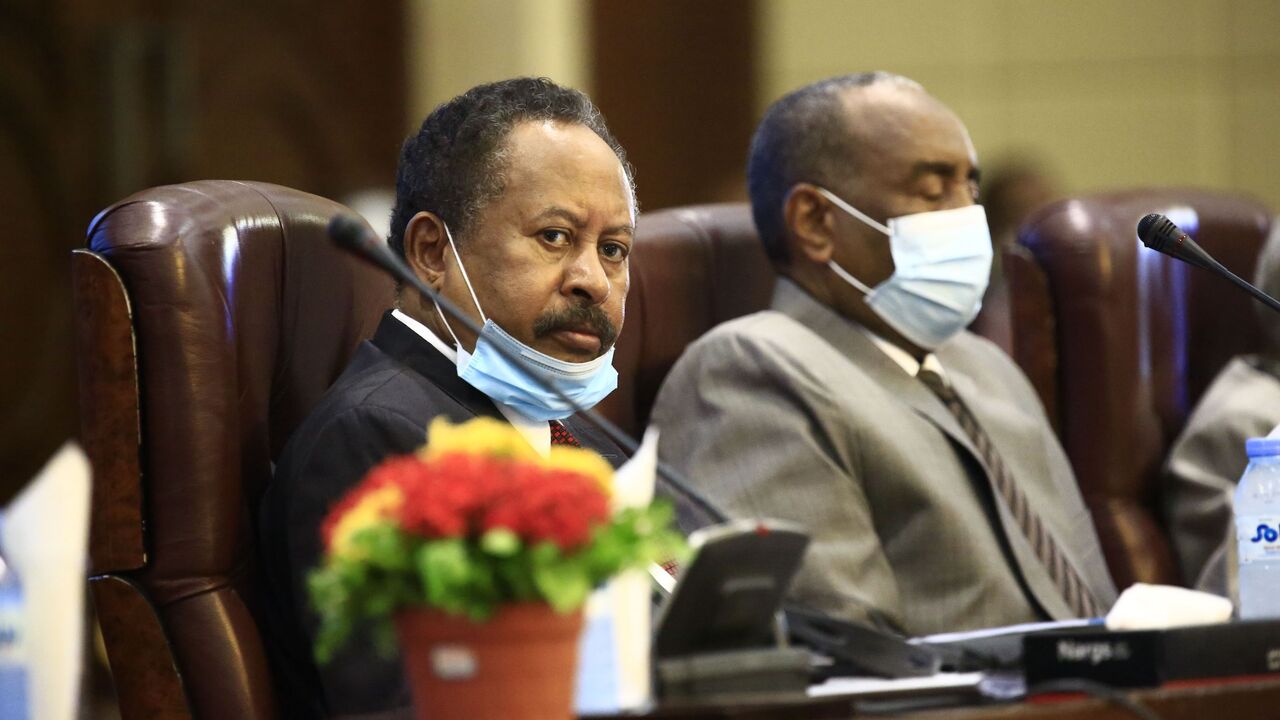 1228716183 (L to R) Sudan's Prime Minister Abdalla Hamdok and the mask-clad (COVID-19 coronavirus pandemic precaution) Sovereign Council chief General Abdel Fattah al-Burhan attend the opening session of the First National Economic Conference in the capital Khartoum on September 26, 2020. (Photo by ASHRAF SHAZLY / AFP) (Photo by ASHRAF SHAZLY/AFP via Getty Images)