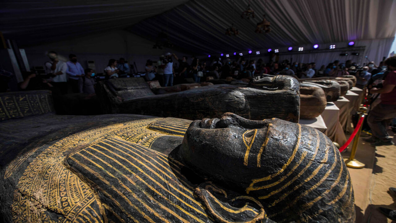 1228864571 A picture taken on October 3, 2020 shows sarcophaguses, excavated by the Egyptian archaeological mission which discovered a deep burial well with more than 59 human coffins closed for more than 2,500 years, displayed during a press conference at the Saqqara necropolis, 30 kms south of the Egyptian capital Cairo. - They were unearthed south of Cairo in the sprawling burial ground of Saqqara, the necropolis of the ancient Egyptian capital of Memphis, a UNESCO World Heritage site. Their exteriors are covered