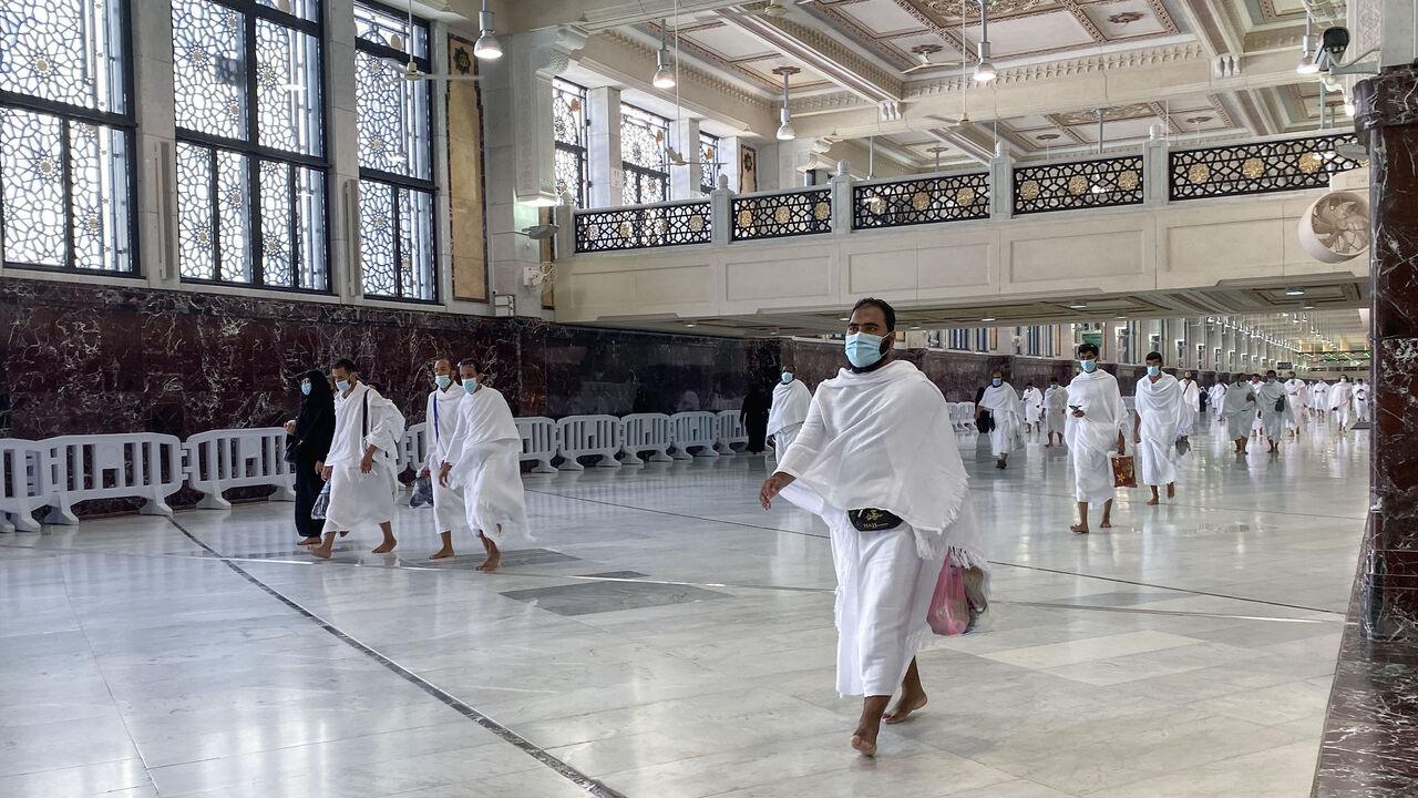 1228883058 Saudis and foreign residents walk down a hallway during Umrah in the Grand Mosque complex in the holy city of Mecca, on October 4, 2020, as authorities partially resume the year-round pilgrimage amid extensive health precautions after a seven-month coronavirus hiatus. (Photo by BANDAR AL-DANDANI / AFP) (Photo by BANDAR AL-DANDANI/AFP via Getty Images)
