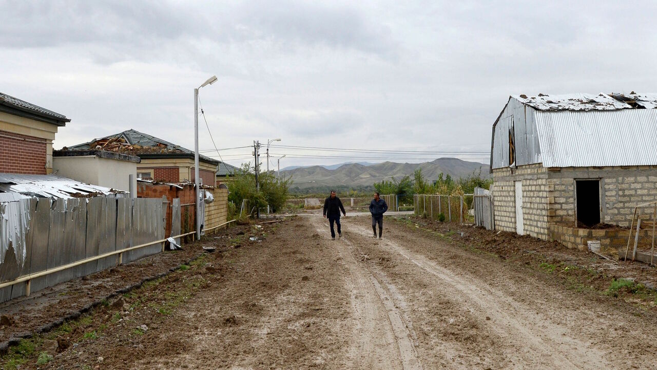 1228919883 Men walk on a street of the village of Djojugh Marjanli in Azerbaijan's Jabrayil district which is said was damaged in shelling during the ongoing fighting between Armenia and Azerbaijan over the breakaway Nagorno-Karabakh region, October 6, 2020. (Photo by TOFIK BABAYEV / AFP) (Photo by TOFIK BABAYEV/AFP via Getty Images)