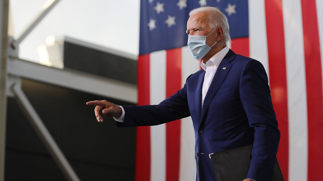 1280063757 MIRAMAR, FLORIDA - OCTOBER 13: Wearing a face mask to reduce the risk posed by the coronavirus, Democratic presidential nominee Joe Biden points to supporters during a drive-in voter mobilization event at Miramar Regional Park October 13, 2020 in Miramar, Florida. With three weeks until Election Day, Biden is campaigning in Florida. (Photo by Chip Somodevilla/Getty Images)