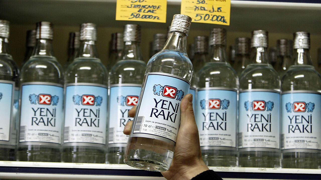 52270558 ISTANBUL, TURKEY: A shop keeper shows a legally produced Turkish Raki in Istanbul 03 March 2005. The deaths of nine people from bootleg liquor has sparked panic in Istanbul drinking establishments, with many bar owners blaming higher taxes on alcoholic beverages by a government with Islamist roots for the emergence of illegal liquor factories. AFP PHOTO/Mustafa Ozer (Photo credit should read MUSTAFA OZER/AFP via Getty Images)