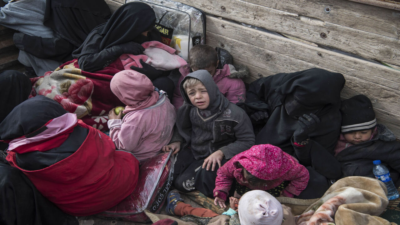 1124896359 Women and children who fled the Islamic State (IS) group's embattled holdout of Baghouz on February 14, 2019, wait in the back of a truck in the eastern Syrian province of Deir Ezzor. - IS jihadists using tunnels and suicide bombers were mounting a desperate defence today of their last square kilometre in eastern Syria.
Kurdish-led forces closed in on the small town of Baghouz where IS fighters and their relatives were hunkered down and met famished and dishevelled people turning themselves in. (Photo by Fa