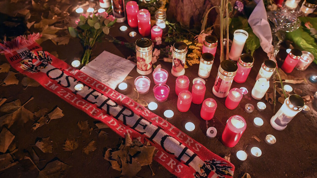 1229442950 Flowers, candles and an Austria scarf are left at a memorial site at the scene of an attack in Vienna, Austria on November 3, 2020, one day after a shooting at multiple locations across central Vienna. - A huge manhunt was under way after gunmen opened fire at multiple locations across central Vienna in the evening of November 2, 2020, killing at least four people in what Austrian Chancellor Sebastian Kurz described as a "repulsive terror attack". (Photo by JOE KLAMAR / AFP) (Photo by JOE KLAMAR/AFP via Get