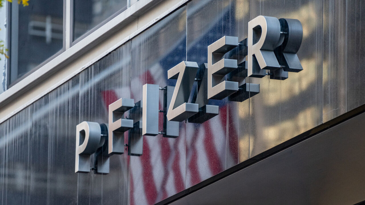 1229555064 NEW YORK, NY - NOVEMBER 09: People walk by the Pfizer headquarters on November 9, 2020 in New York City. Pharmaceutical company Pfizer announced positive early results on its COVID-19 vaccine trial and has proven to be 90% effective in preventing infection of the virus. (Photo by David Dee Delgado/Getty Images)