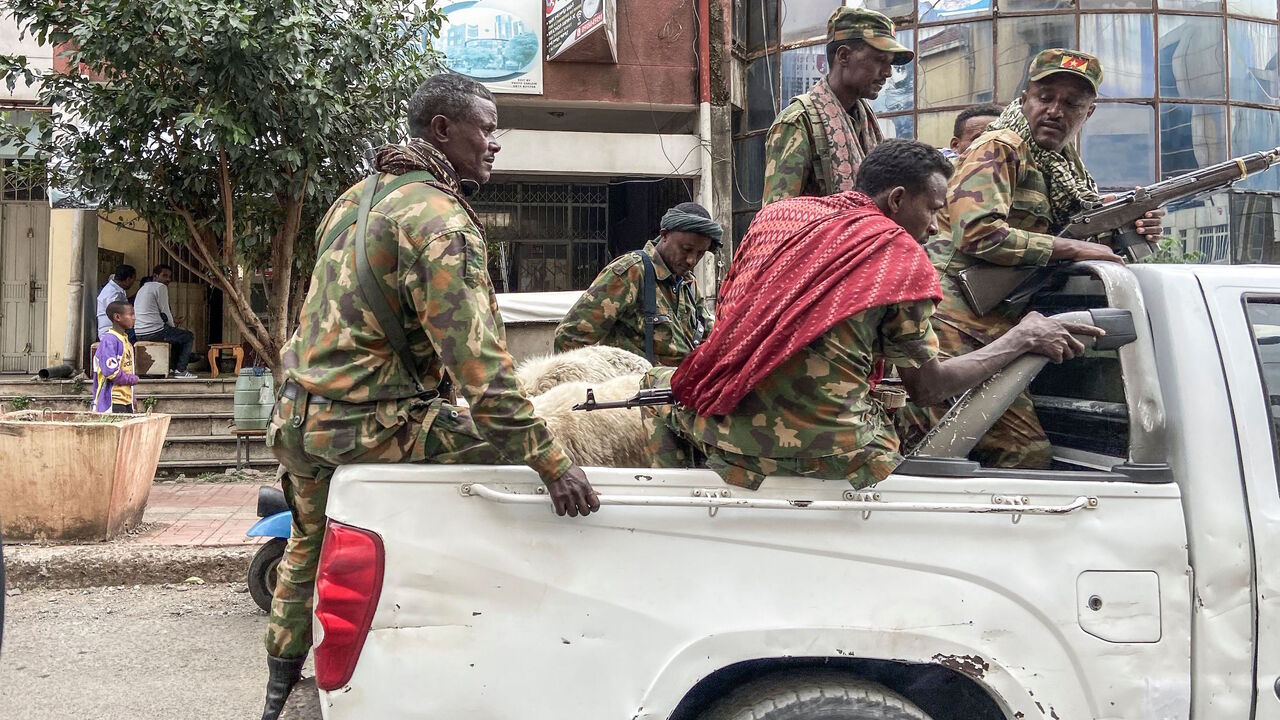 1229562168 TOPSHOT - Members of the Amhara militia, that combat alongside federal and regional forces against northern region of Tigray, ride on the back of a pick up truck in the city of Gondar, on 08 November 2020. (Photo by EDUARDO SOTERAS / AFP) (Photo by EDUARDO SOTERAS/AFP via Getty Images)