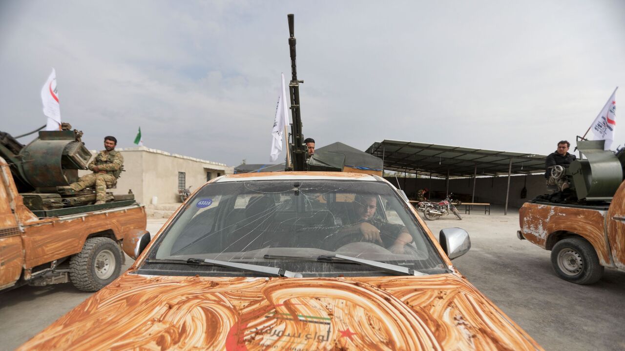 1229617411 Turkish-backed Syrian rebel fighters, mask-clad due to the COVID-19 coronavirus pandemic, take part in a military parade marking the graduation of a new batch of cadets and attended by officials from the Turkey-backed opposition in the town of Jindayris, in the Afrin region of the northern Syrian rebel-held province of Aleppo, on November 14, 2020. (Photo by Bakr ALKASEM / AFP) (Photo by BAKR ALKASEM/AFP via Getty Images)