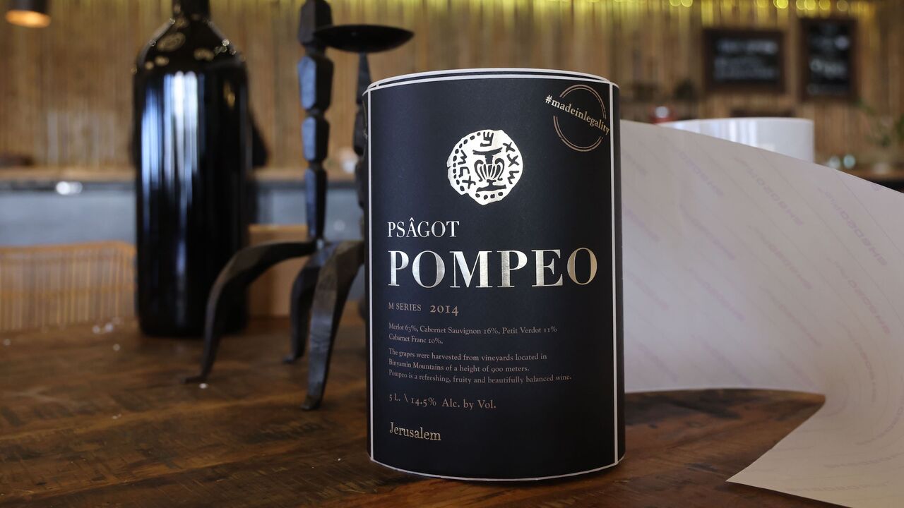 1229679244 Wine labels named after US Secretary of State Mike Pompeo await to be put on a bottle at Israeli winemaker Yaakov Berg's Psagot Winery, in the settlers industrial park of Sha'ar Binyamin near the Israeli Psagot settlement in the occupied West Bank north of Jerusalem on November 18, 2020. - Berg's decision to name his red blend after US Secretary Mike Pompeo may capture attention, but for him the hashtag on the label's top right corner "#madeinlegality" is just as important, categorically rejecting the notio