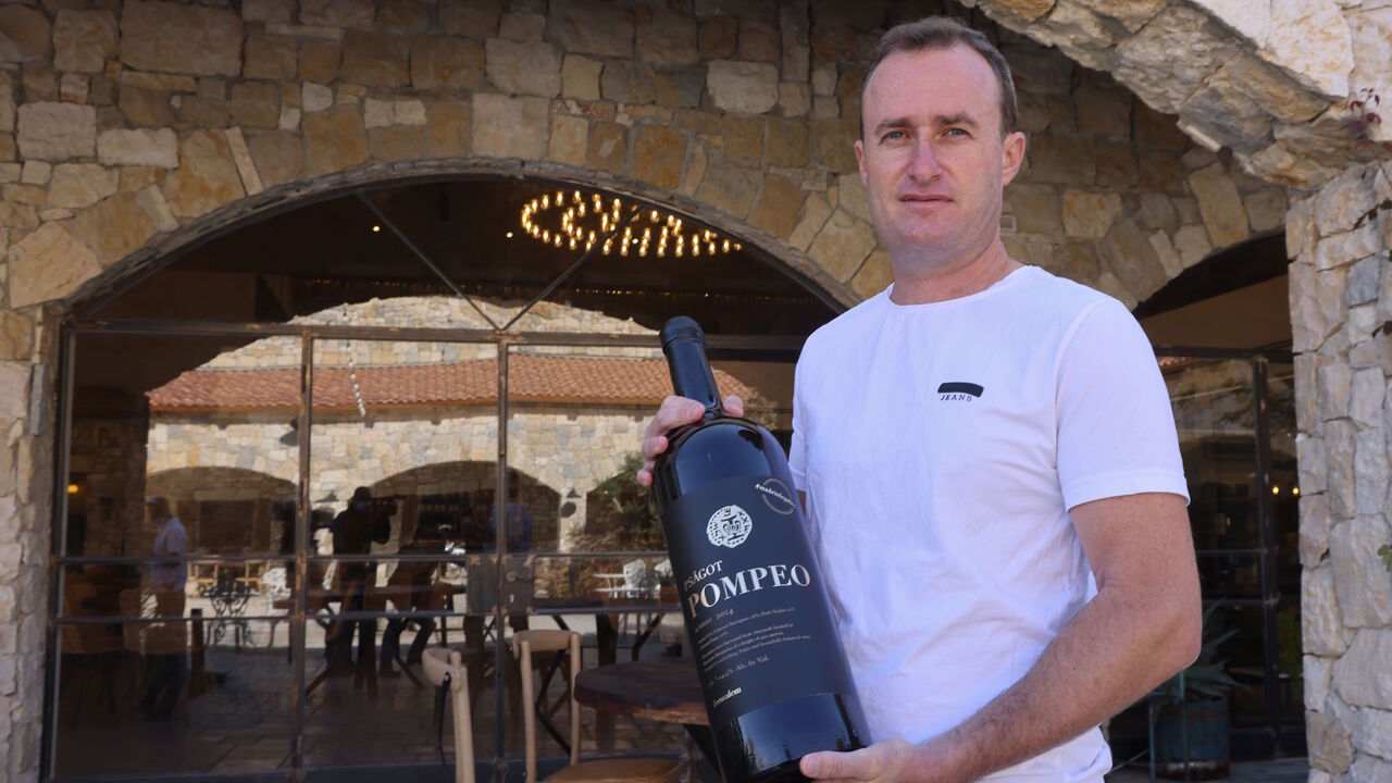 1229679249 Israeli winemaker Yaakov Berg's holds a bottle of his red blend named after US Secretary of State Mike Pompeo at the Psagot Winery in the settlers industrial park of Sha'ar Binyamin near the Israeli Psagot settlement in the occupied West Bank north of Jerusalem on November 18, 2020. - Berg's decision to name his red blend after US Secretary Mike Pompeo may capture attention, but for him the hashtag on the label's top right corner "#madeinlegality" is just as important, categorically rejecting the notion tha
