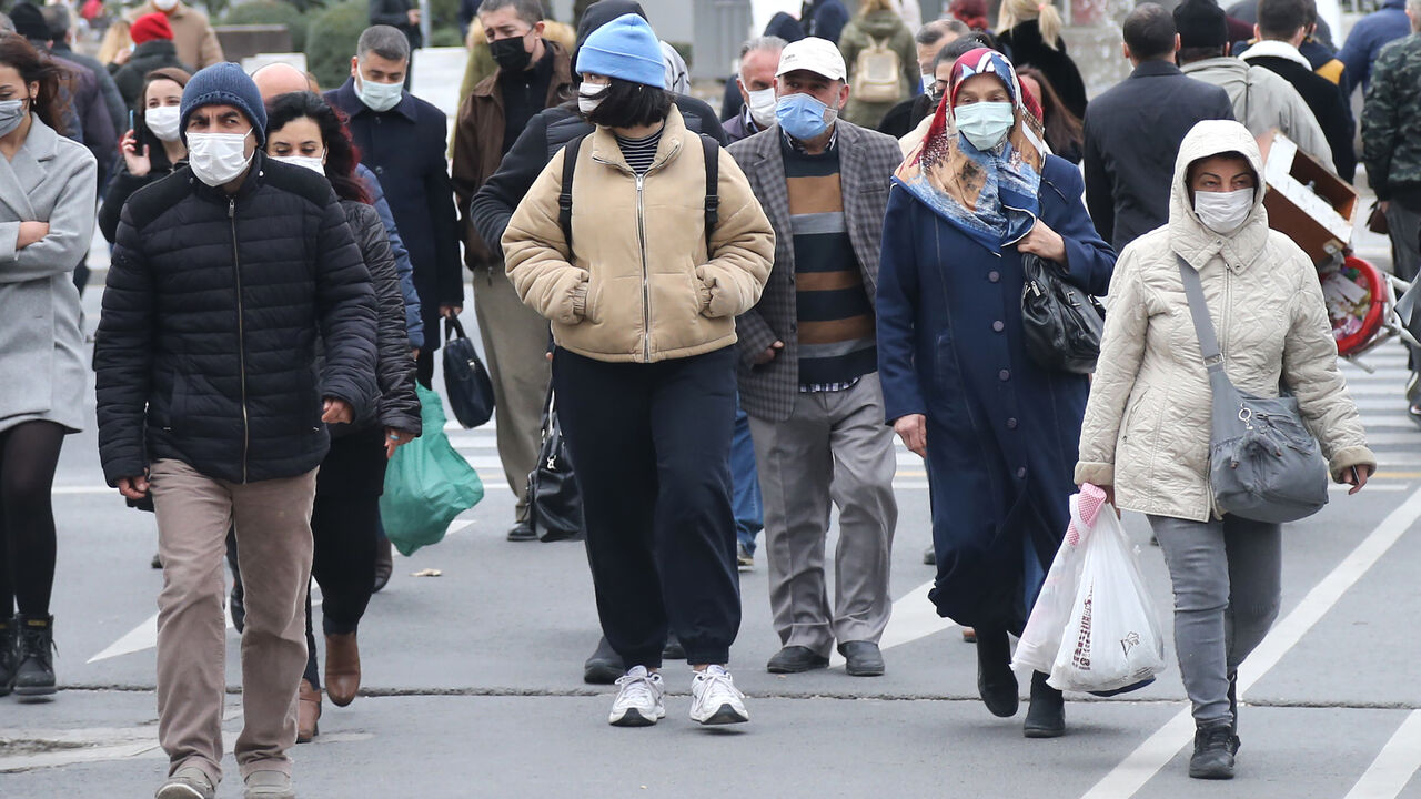 1229699137 Pedestrians, wearing face masks, walk in a street of Ankara on November 20, 2020. - Turkey has set a new record on November 20, 2020, confirming 5,103 new COVID-19 patients and 141 deaths, the highest numbers since the start of the pandemic in the country. (Photo by Adem ALTAN / AFP) (Photo by ADEM ALTAN/AFP via Getty Images)