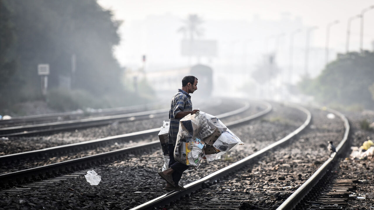 492239704 A picture taken on October 11, 2015 shows a man walking on a railway as a train approaches in the Egyptian capital Cairo. AFP PHOTO / MOHAMED EL-SHAHED (Photo credit should read MOHAMED EL-SHAHED/AFP via Getty Images)