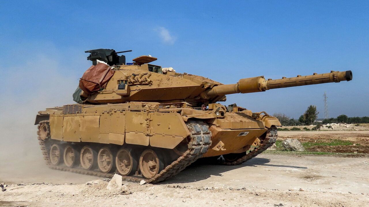 1207206728 A Turkish military M60T battle tank is seen along the M4 highway, which links the northern Syrian provinces of Aleppo and Latakia, before incoming joint Turkish and Russian military patrols (as per an earlier agreed upon ceasefire deal) in the village of al-Nayrab, about 14 kilometres southeast of the city of Idlib and seven kilometres west of Saraqib in northwestern Syria on March 15, 2020. - Russian President Vladimir Putin and his Turkish counterpart Recep Tayyip Erdogan reached a deal on March 5 to crea