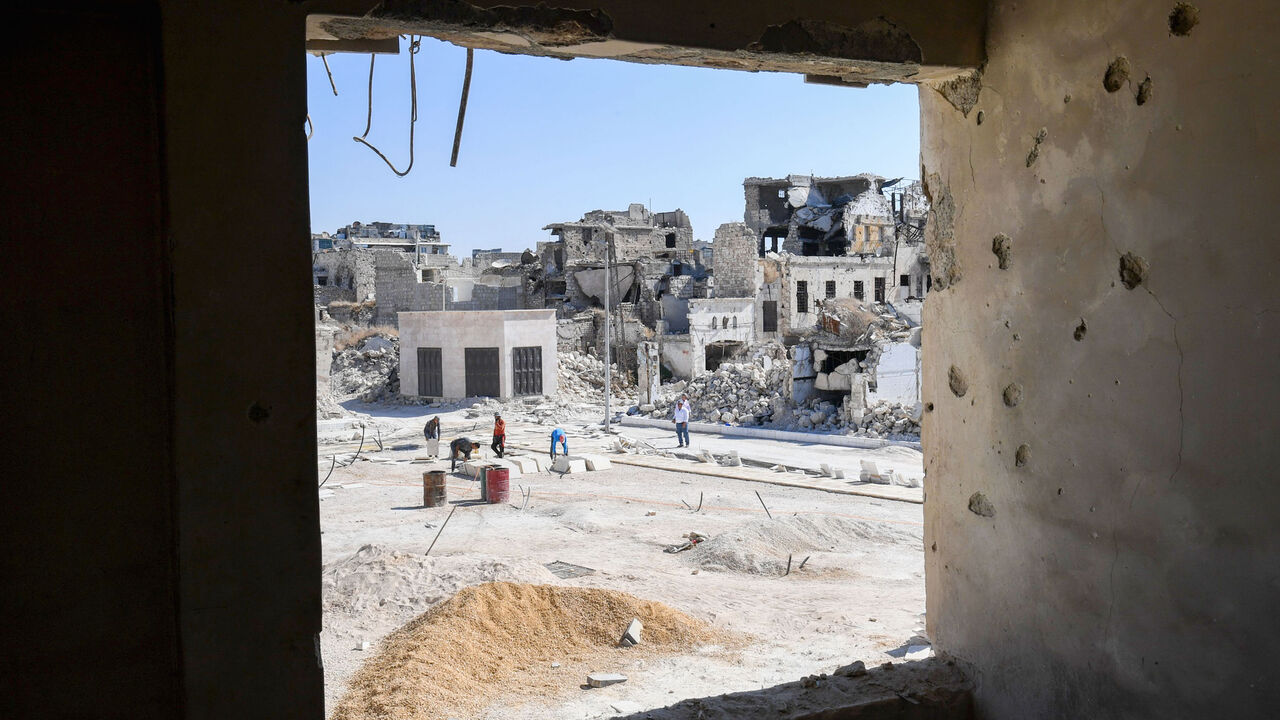 1229119236 Syrian workers take part in the reconstruction of the Hatab Square in the Jdaideh neighbourhood in Aleppo's Old City on October 17, 2020. (Photo by - / AFP) (Photo by -/AFP via Getty Images)