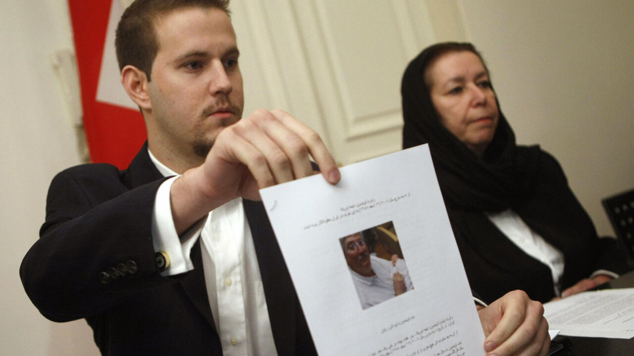 78624563 US Daniel Levinson (L) shows a picture of his father, ex-FBI agent Robert Levinson, holding his grandson Ryan during a press conference with his mother Christine at the Swiss embassy in Tehran, 22 December 2007. The wife of the former agent missing in Iran since March said today she has received "no answers" about his fate at the end of her trip to the Islamic republic in search of her husband, who Washington says went missing on a visit to the Iranian island of Kish. The Tehran government reiterated earlie