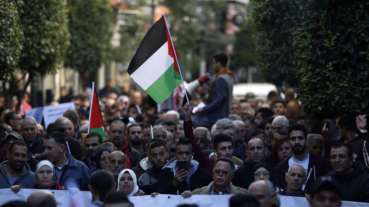 1081243904 Palestinians wave national flags as they march in the streets of the occupied West Bank city of Ramallah, calling for the cessation of divisions between Fatah and Hamas and the unification of the West Bank and Gaza Strip, on January 12, 2019. (Photo by ABBAS MOMANI / AFP) (Photo credit should read ABBAS MOMANI/AFP via Getty Images)
