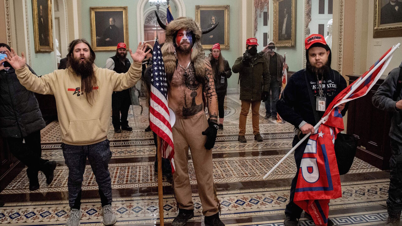 1230468102 Supporters of US President Donald Trump, including Jake Angeli (C), a QAnon supporter known for his painted face and horned hat, enter the US Capitol on January 6, 2021, in Washington, DC. - Demonstrators breeched security and entered the Capitol as Congress debated the a 2020 presidential election Electoral Vote Certification. (Photo by SAUL LOEB / AFP) (Photo by SAUL LOEB/AFP via Getty Images)