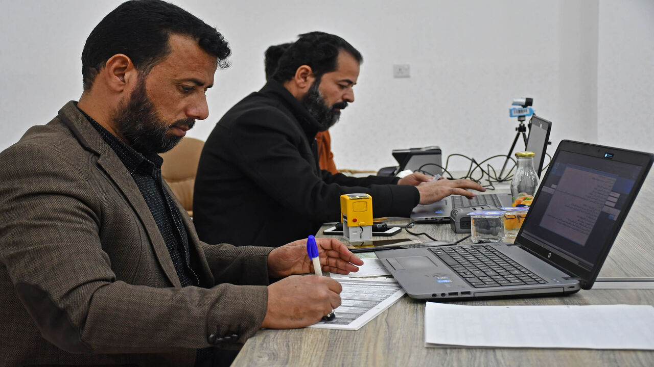 1230546282 Employees of Iraq's Independent High Electoral Commission Center register voters in the southern Iraqi city of Nasiriyah in the Dhi Qar province, on January 12, 2021. - Iraq's early parliamentary elections were promised by the PM for June but according to officials and politicians they are highly unexpected to be held without several month of delay. (Photo by Asaad NIAZI / AFP) (Photo by ASAAD NIAZI/AFP via Getty Images)