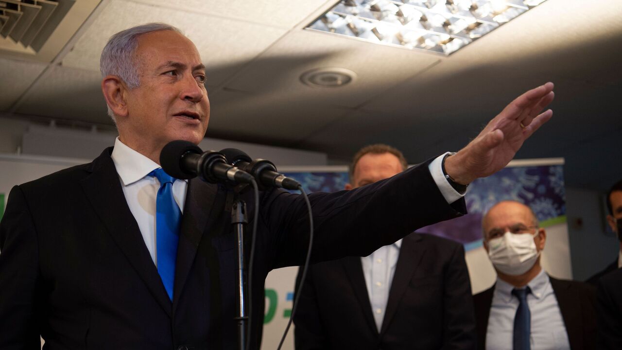 1230564557 Israel's Prime Minister Benjamin Netanyahu visits the anti-coronavirus vaccination facility in the northern Israeli Arab city of Nazareth on January 13, 2021. - A group of Arab Israelis demonstrated against Netanyahu's visit to the fascililty in their city. Since July, thousands of Israelis have rallied each week to protest against the prime minister and the economic fallout from the pandemic. (Photo by Gil ELIYAHU / POOL / AFP) (Photo by GIL ELIYAHU/POOL/AFP via Getty Images)