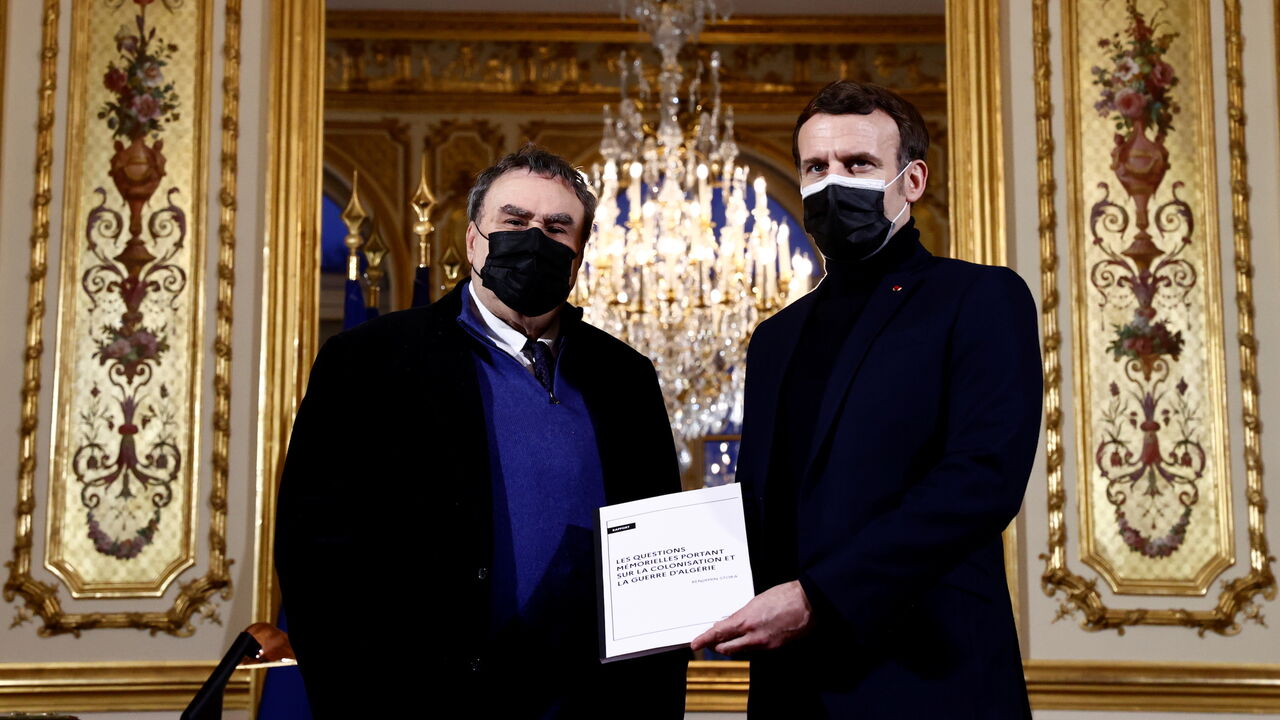 1230692525 French President Emmanuel Macron (R) poses with French historian Benjamin Stora for the delivery of a report on the colonisation and the Algerian War at the Elysee Palace in Paris on January 20, 2021. - Stora on January 20, 2021, proposed to the French president to create a in France "Memory and Truth" commission, in charge of proposing "common initiatives between France and Algeria on issues of memory" in order to reconcile the two countries. (Photo by CHRISTIAN HARTMANN / POOL / AFP) (Photo by CHRISTIAN H