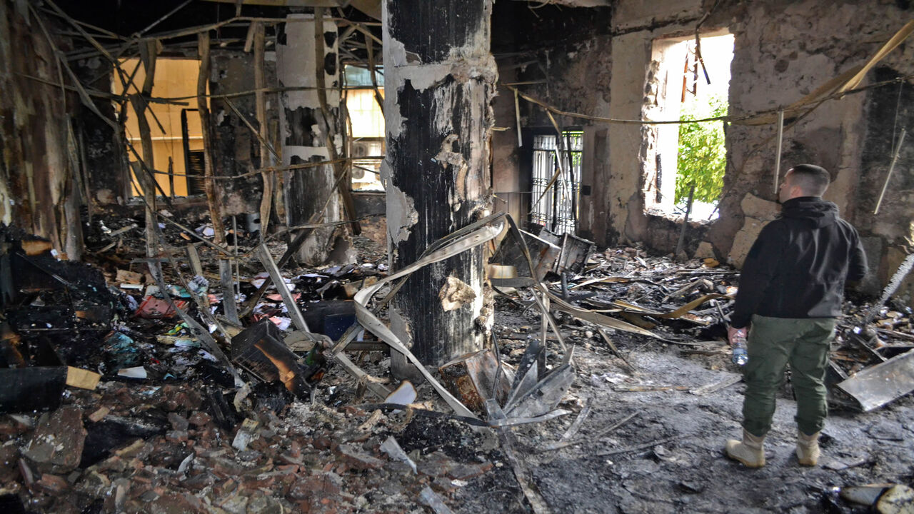 1230849795 People inspect a burnt room at municipality building, in the impoverished northern Lebanese port city of Tripoli, after anti-government protesters hurled improvised incendiary devices amid clashes with security forces the previous night, on January 29, 2021. (Photo by Fathi AL-MASRI / AFP) (Photo by FATHI AL-MASRI/AFP via Getty Images)