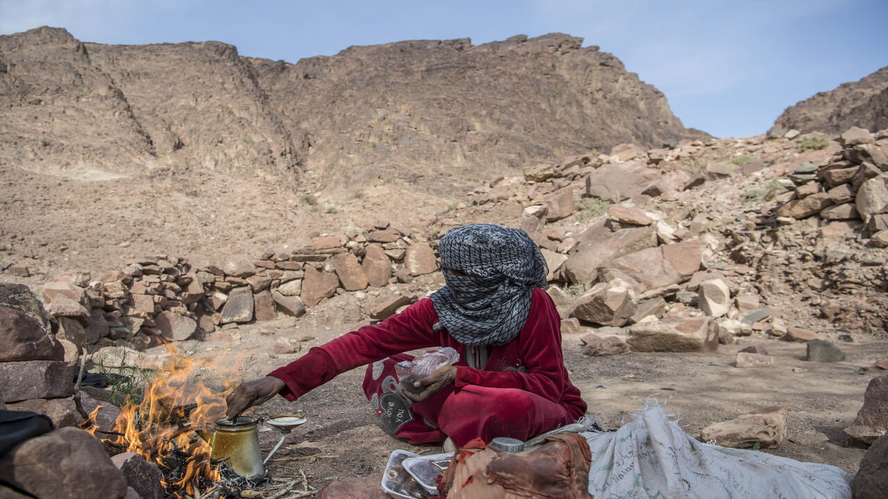 1134775152 Umm Yasser, an Egyptian Bedouin woman guide from the Hamada tribe, prepares tea for a group of hikers in Wadi el-Sahu in South Sinai governorate on March 29, 2019, during the first "Sinai Trail" led by Bedouin women guides. - In Wadi Sahu, a village in the southern part of Egypt's eastern Sinai peninsula, made up of humble shacks with corrugated iron and recycled scraps, Bedouins are banking on the return of tourism after the tumultuous years since Egypt's 2011 uprising. (Photo by Khaled DESOUKI / AFP)