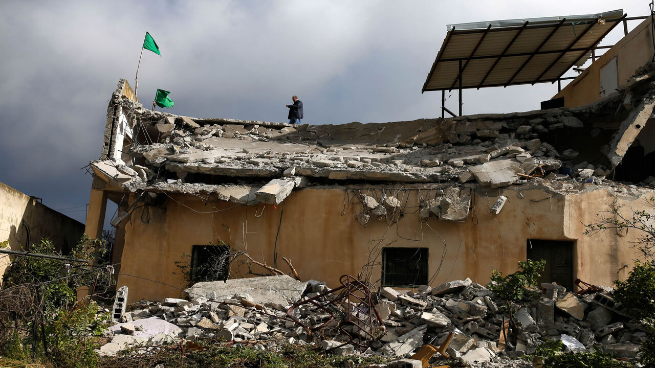1137677159 Hamas flags stand on the roof of the house of Palestinian assailant Salah Barghouti after it was partially demolished by Israeli forces in the village of Kobar near Ramallah, in the Israeli-occupied West Bank, on April 17, 2019. - Israeli forces destroyed the home of the Palestinian who was killed during his attempted arrest on suspicion of carrying out a December shooting. Seven people were wounded in the December 9 attack near the Israeli settlement of Ofra in the occupied West Bank, one of them a pregnan