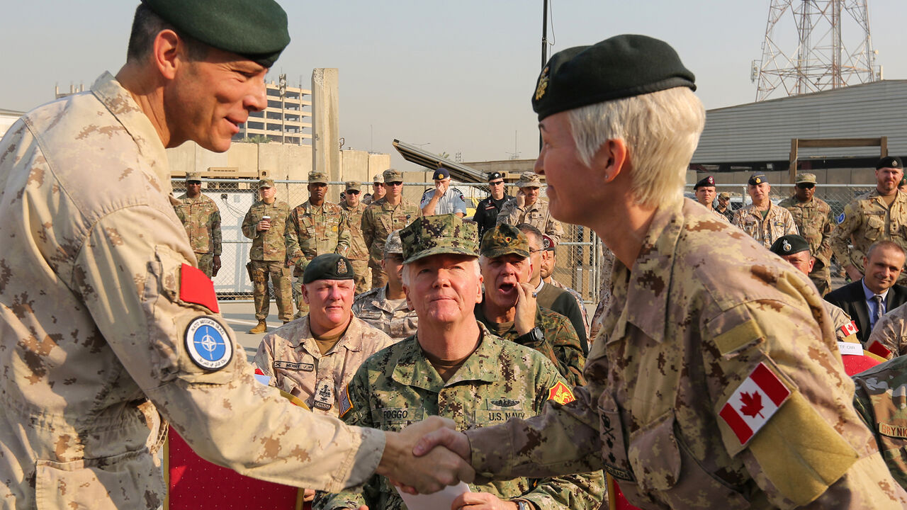 1184744198 Jennie Carignan (R), the incoming commander of NATO's Iraq mission, is greeted by Dany Fortin, the outgoing commander of NATO's Iraq mission, during the handover ceremony in the Iraqi capital Baghdad on November 26, 2019. (Photo by SABAH ARAR / AFP) (Photo by SABAH ARAR/AFP via Getty Images)