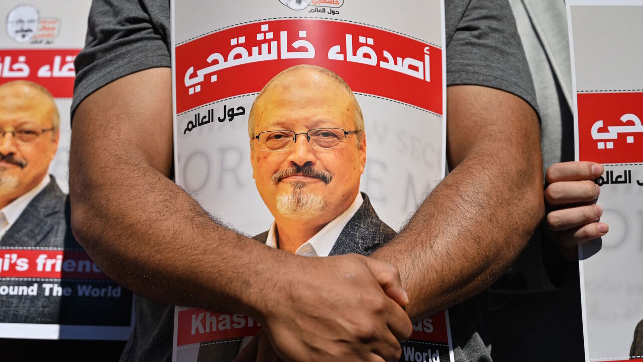 1228843131 Friends of murdered Saudi journalist Jamal Khashoggi hold posters bearing his picture as they attend an event marking the second-year anniversary of his assassination in front of Saudi Arabia Istanbul Consulate, on October 2, 2020. - Khashoggi, a Washington Post columnist, was killed and dismembered at the Saudi consulate in Istanbul on October 2, 2018, in an operation that reportedly involved 15 agents sent from Riyadh. His remains have not been found. (Photo by Ozan KOSE / AFP) (Photo by OZAN KOSE/AFP via
