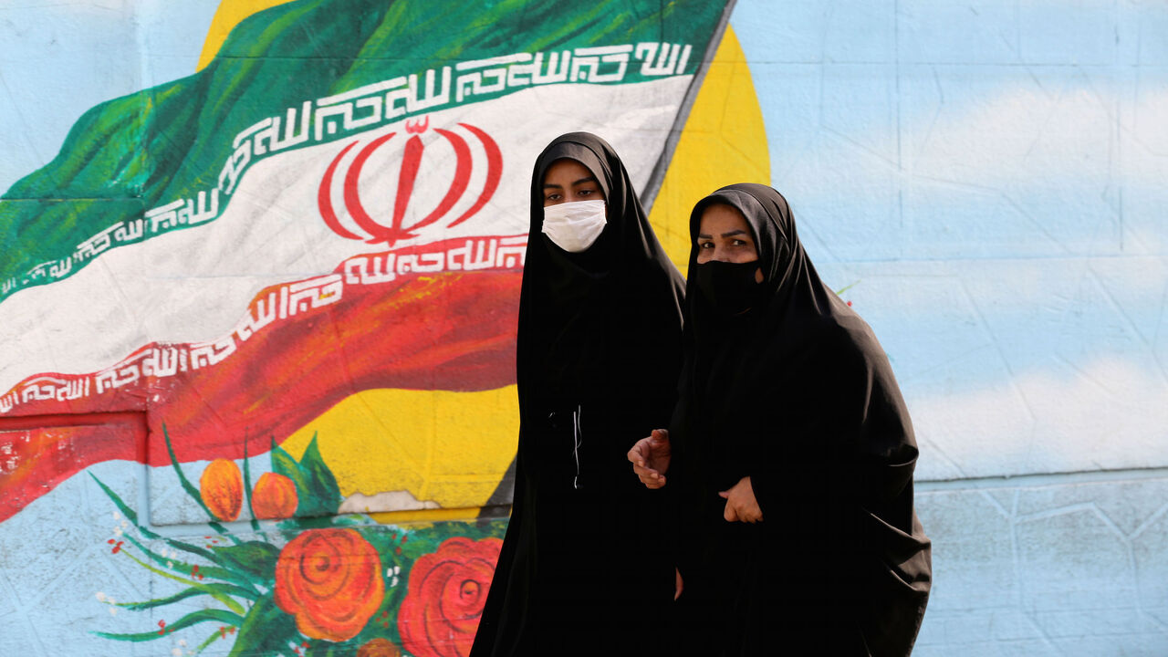 1229867624 Women walk while wearing face masks amid the COVID-19 pandemic in the Iranian capital Tehran, on November 30, 2020. (Photo by ATTA KENARE / AFP) (Photo by ATTA KENARE/AFP via Getty Images)