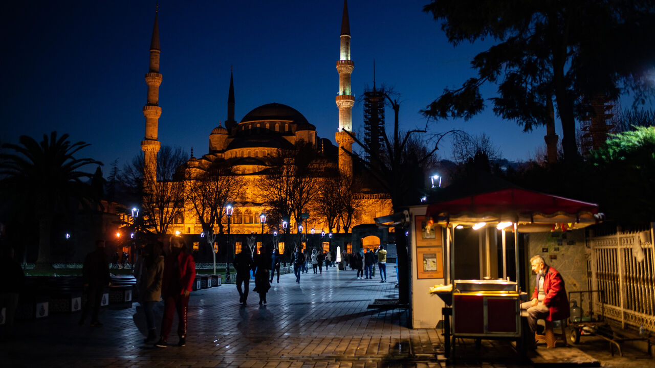 1230373004 A street vendor sits in front of the Blue Mosque during the new year's celebrations in Istanbul on December 31, 2020. - Turkish government announced a four-days lockdown between December 31 and January 04, 2021. (Photo by Yasin AKGUL / AFP) (Photo by YASIN AKGUL/AFP via Getty Images)