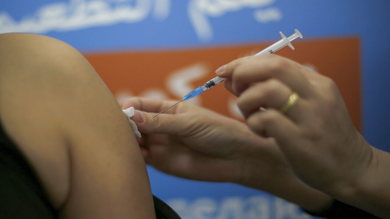 1230566401 A Druze woman gets vaccinated against the COVID-19 coronavirus at the Kupat Holim Meuhedet clinic in the Druze village of Ein Quniya in the Israeli-annexed Golan Heights on January 13, 2021. (Photo by JALAA MAREY / AFP) (Photo by JALAA MAREY/AFP via Getty Images)