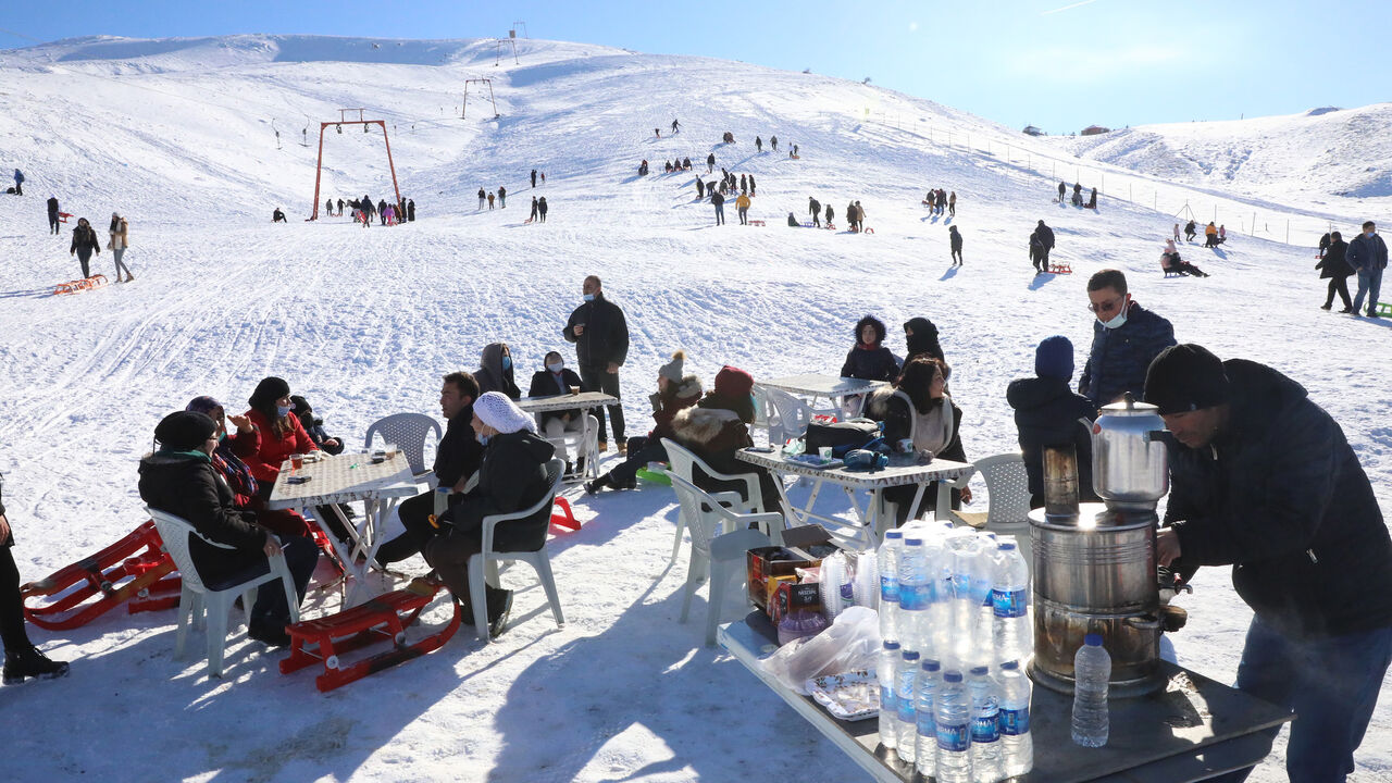 1230730285 People sit at tables, at the Elmadag Ski Resort in Ankara, on January 22, 2021, after a snowfall. (Photo by Adem ALTAN / AFP) (Photo by ADEM ALTAN/AFP via Getty Images)