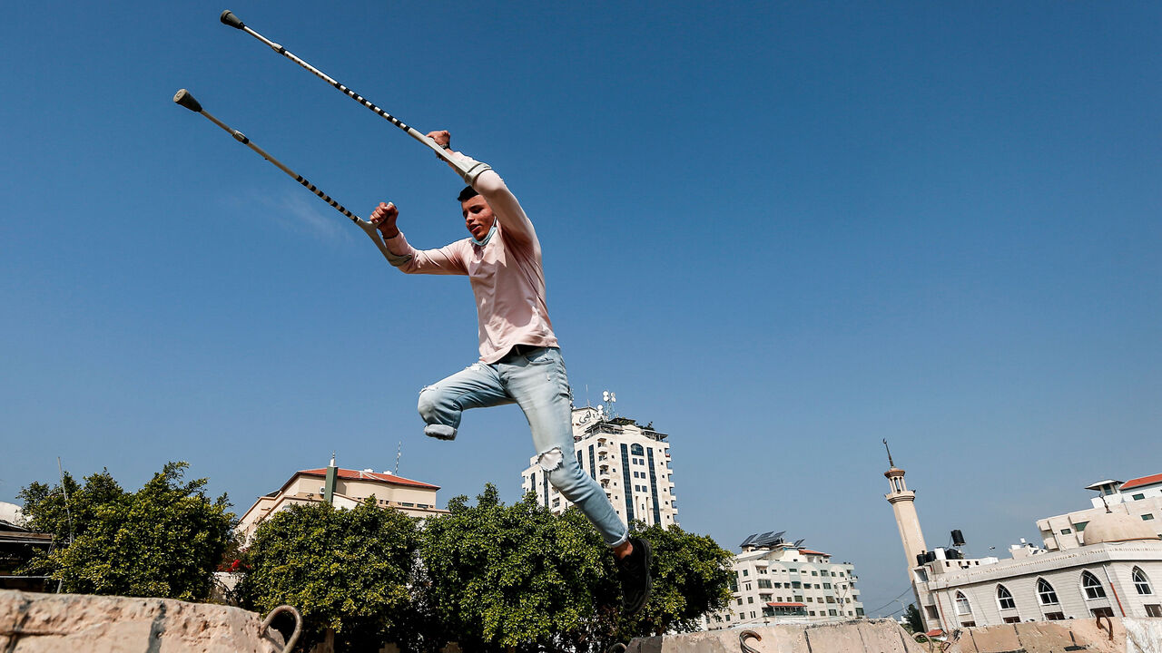 1230775684 Mohamed Aliwa, a Palestinian youth whose leg was amputated near the knee in 2018 after he was hit by Israeli army fire during protests along the fortified border separating the Gaza Strip from Israel, shows off his parkour skills despite his disability and while on crutches in Gaza City on January 4, 2021. - Parkour, an extreme sport also known as free-running, originated in France in the 1990s. Young people in the Gaza Strip have been practising parkour for years; bounding from ruin to ruin in an enclave p