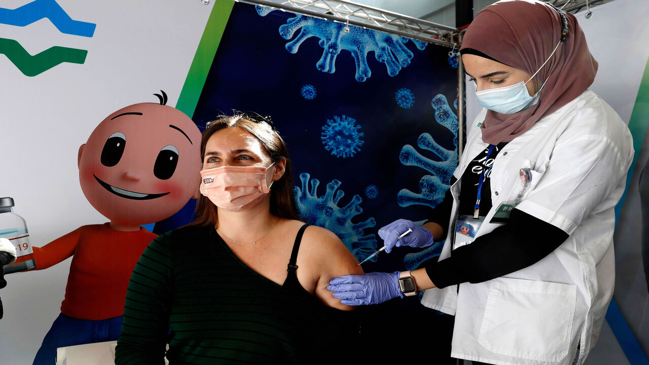 1230911611 A health worker administers a dose of the Pfizer-BioNtech COVID-19 vaccine at Clalit Health Services, in a gymnasium in the Israeli city of Petah Tikva, on February 1, 2021. - Israel's nationwide lockdown was extended to contain the coronavirus which has continued to spread rapidly as the country presses ahead with an aggressive vaccination campaign. (Photo by JACK GUEZ / AFP) (Photo by JACK GUEZ/AFP via Getty Images)