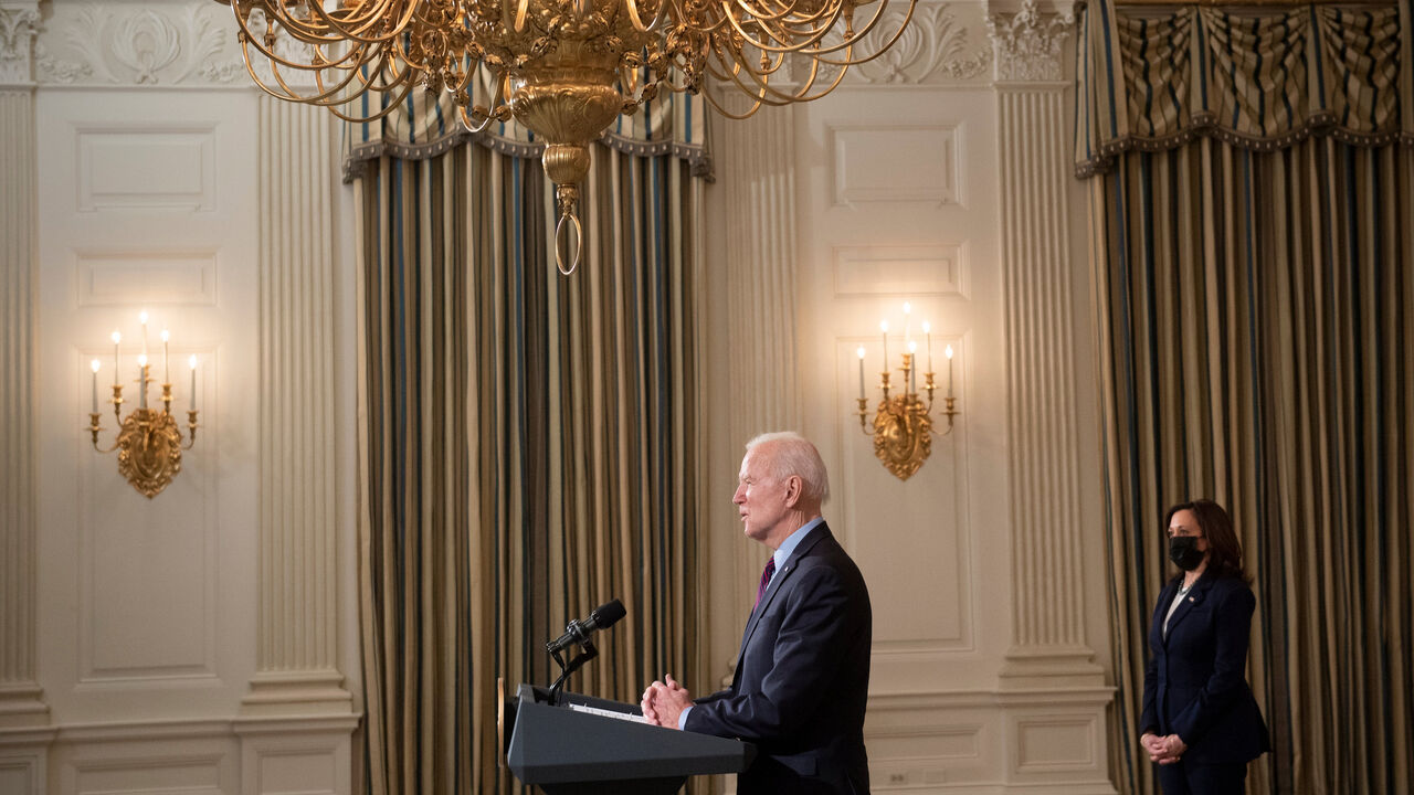 1230985941 US Vice President Kamala Harris (R) listens while US President Joe Biden speaks about COVID-19 relief from the State Dining Room of the White House February 5, 2021, in Washington, DC. (Photo by Brendan Smialowski / AFP) (Photo by BRENDAN SMIALOWSKI/AFP via Getty Images)