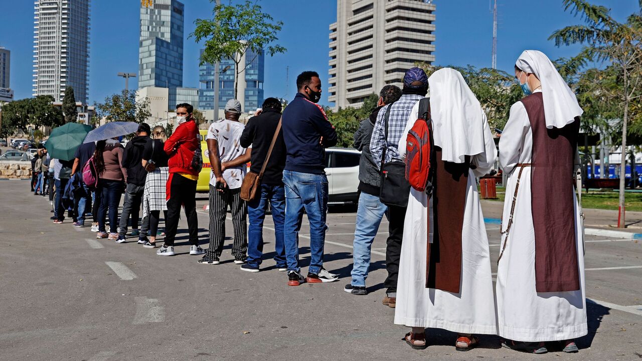 1231059426 French nuns living in Israel queue with other foreign residents to receive a dose of COVID-19 coronavirus vaccine at the Tel Aviv Sourasky Medical Centre for foreign nationals in the Mediterranean coastal city of Tel Aviv on February 9, 2021 during a campaign to vaccinate foreign workers and refugees against coronavirus. (Photo by JACK GUEZ / AFP) (Photo by JACK GUEZ/AFP via Getty Images)