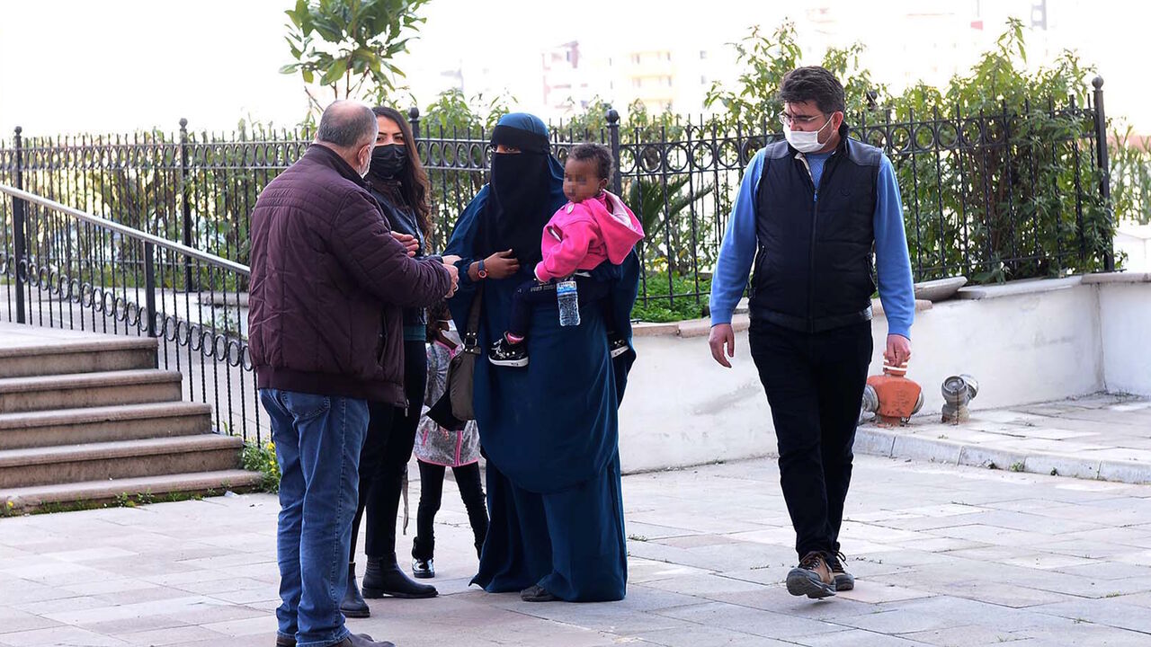 1231196275 A handout picture taken on February 15, 2021 shows a 26-year-old woman (R), who had held New Zealand and Australian citizenships, and her two children escorted by Turkish plain clothes police officers after trying to enter Turkey illegally from Syria at Reyhanli district in Hatay. - New Zealand Prime Minister Jacinda Ardern angrily accused Australia on February 16, 2021 of shirking its responsibility for a dual national arrested in Turkey with alleged links to the Islamic State militant group. The 40-year-o