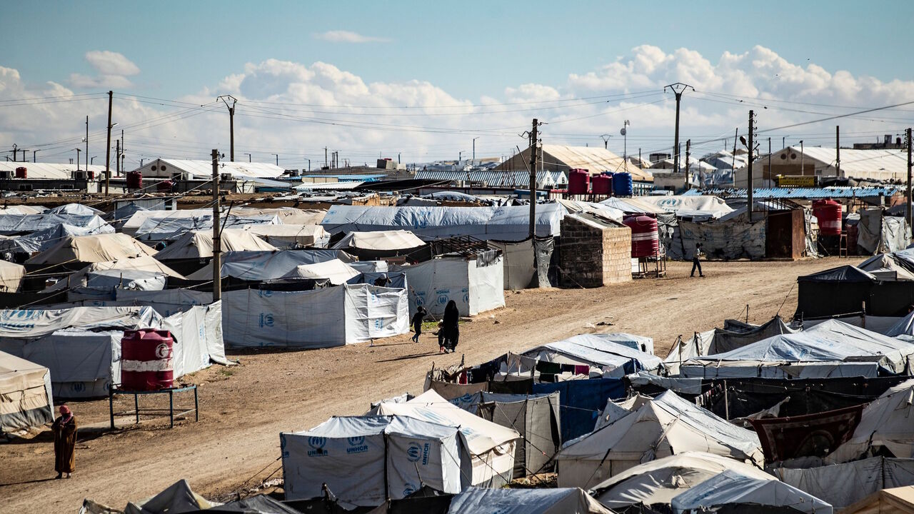1231220583 People walk among tents at the Kurdish-run al-Hol camp which holds suspected relatives of Islamic State (IS) group fighters, in the northeastern Syrian Hasakeh governorate, on February 17, 2021. (Photo by Delil SOULEIMAN / AFP) (Photo by DELIL SOULEIMAN/AFP via Getty Images)