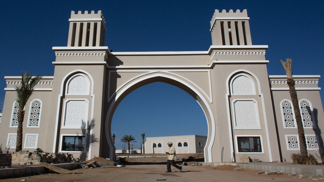 519095010 SHARM EL SHEIKH, EGYPT - APRIL 03: A man walks in front of a new hotel under construction in Nabq district on April 3, 2016 in Sharm El Sheikh, Egypt. Prior to the Arab Spring in 2011 some 15million tourists would visit Egypt each year. The resort town of Sharm El Sheikh was built around tourism however tourist numbers have plummeted after recent terrorist attacks with flights from major UK carriers being suspended and foreign offices around the world warning citizens of the 'High threat from terrorism' Sha
