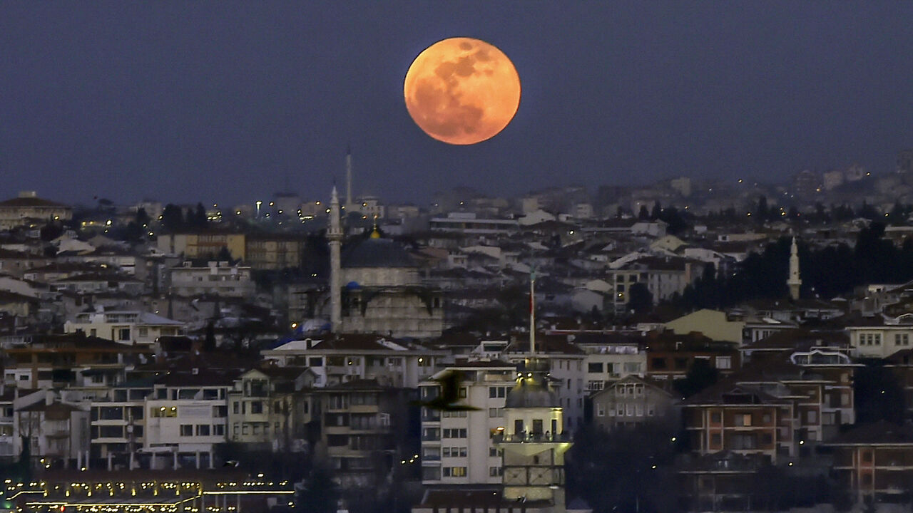 912699248 A picture taken on January 31, 2018 shows the moon during a lunar eclipse, referred to as the "super blue blood moon" up in the sky above the Bosphorus straits in Istanbul. - Skywatchers were hoping for a rare lunar eclipse that combines three unusual events -- a blue moon, a super moon and a total eclipse -- which was to make for a large crimson moon viewable in many corners of the globe. (Photo by YASIN AKGUL / AFP) (Photo credit should read YASIN AKGUL/AFP via Getty Images)