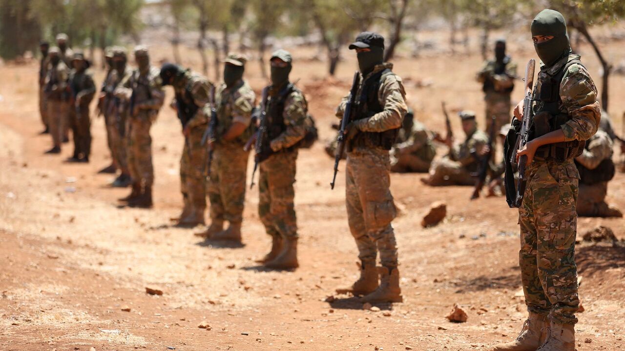 1016746136 Syrian fighters attend a mock battle in anticipation of an attack by the regime on Idlib province and the surrounding countryside, during a graduation of new Hayat Tahrir al-Sham (HTS) members at a camp in the countryside of the northern Idlib province on August 14, 2018. (Photo by OMAR HAJ KADOUR / AFP) (Photo credit should read OMAR HAJ KADOUR/AFP via Getty Images)