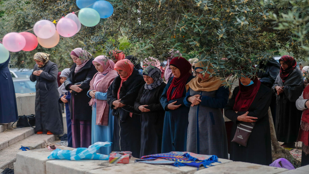 1214817460 Palestinian women worshippers gather to attend the prayers of Eid al-Fitr, the Muslim holiday which starts at the conclusion of the holy fasting month of Ramadan, outside the closed Aqsa mosque complex in Jerusalem's old city early on May 24, 2020. - Muslims around the world began marking a sombre Eid al-Fitr, many under coronavirus lockdown, but lax restrictions offer respite to worshippers in some countries despite fears of skyrocketing infections. Jerusalem's Al-Aqsa mosque, Islam's third holiest site, w